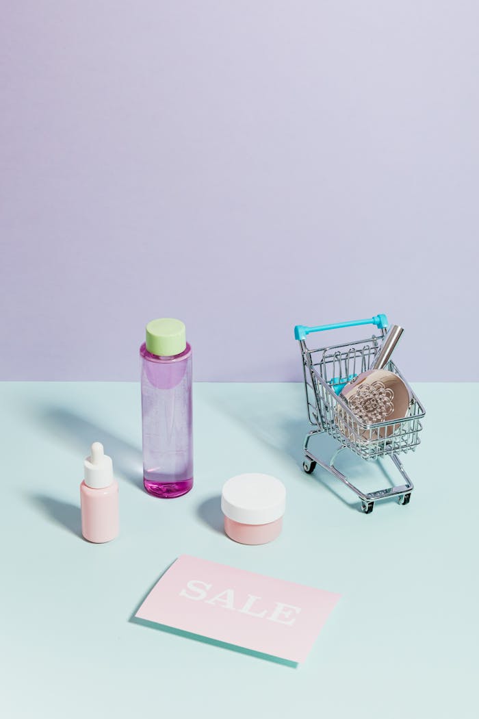 Elegant flatlay of cosmetics and a mini shopping cart, ideal for sales promotions.